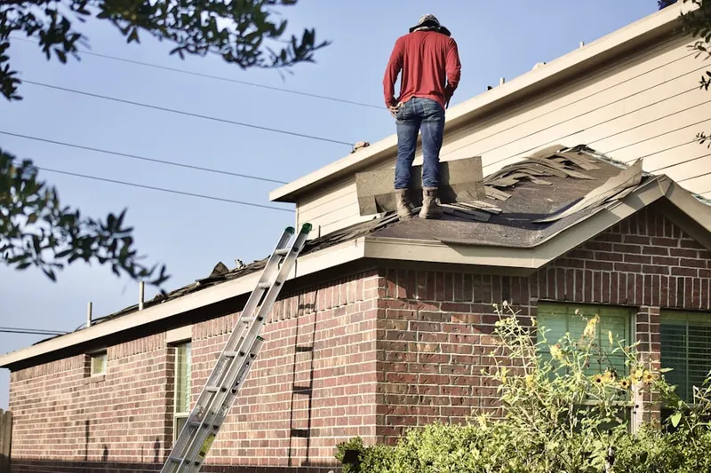 Professional roofer working on a residential roof in Country Club Park